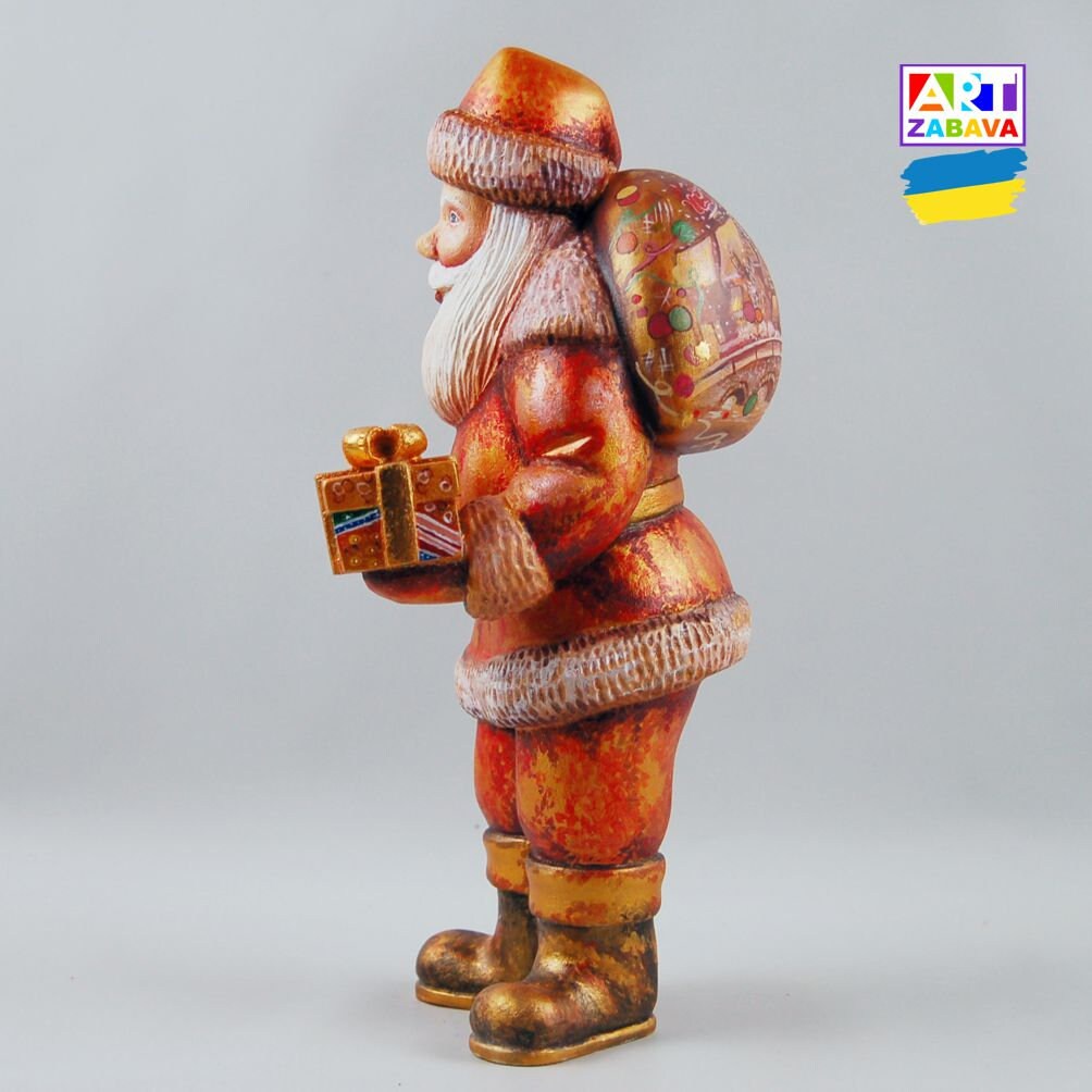 9.25-inch custom order hand-carved and painted Santa Claus wooden figurine with gift and bag, featuring detailed craftsmanship and Christmas design.